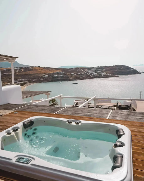 Witte spa voor 3 personen met bubbels, ideaal als jacuzzi buiten of swimspa op houten terras met zeezicht.