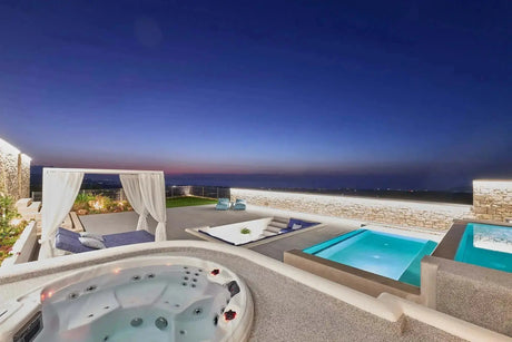 Luxe 7-persoons jacuzzi buiten met ingebouwde jets naast moderne zwemspa en swimspa bij zonsondergang.