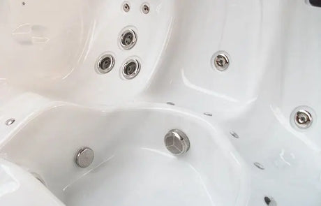 Witte jacuzzi met meerdere jetdoppen en ergonomische zitplaatsen, ideaal voor zwemspa buitengebruik.