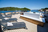 Moderne 6-persoons jacuzzi buiten met houten omlijsting, ligstoelen en uitzicht op zwemspa water.